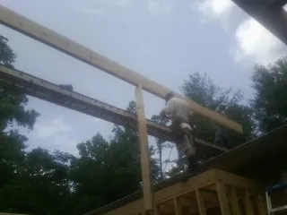 Carpenter setting a ridge beam over a new addition frame — Ice Dam Removal by Roofing Brothers in Olathe