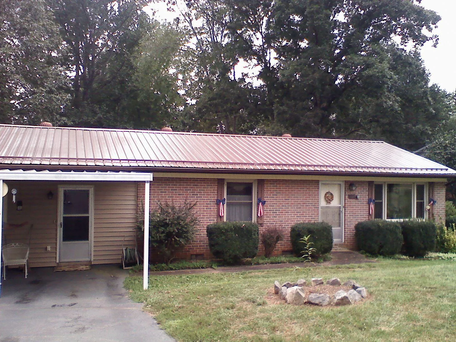 Bronze metal roof and carport on a brick ranch home — Roof Repair work by our crew in Olathe
